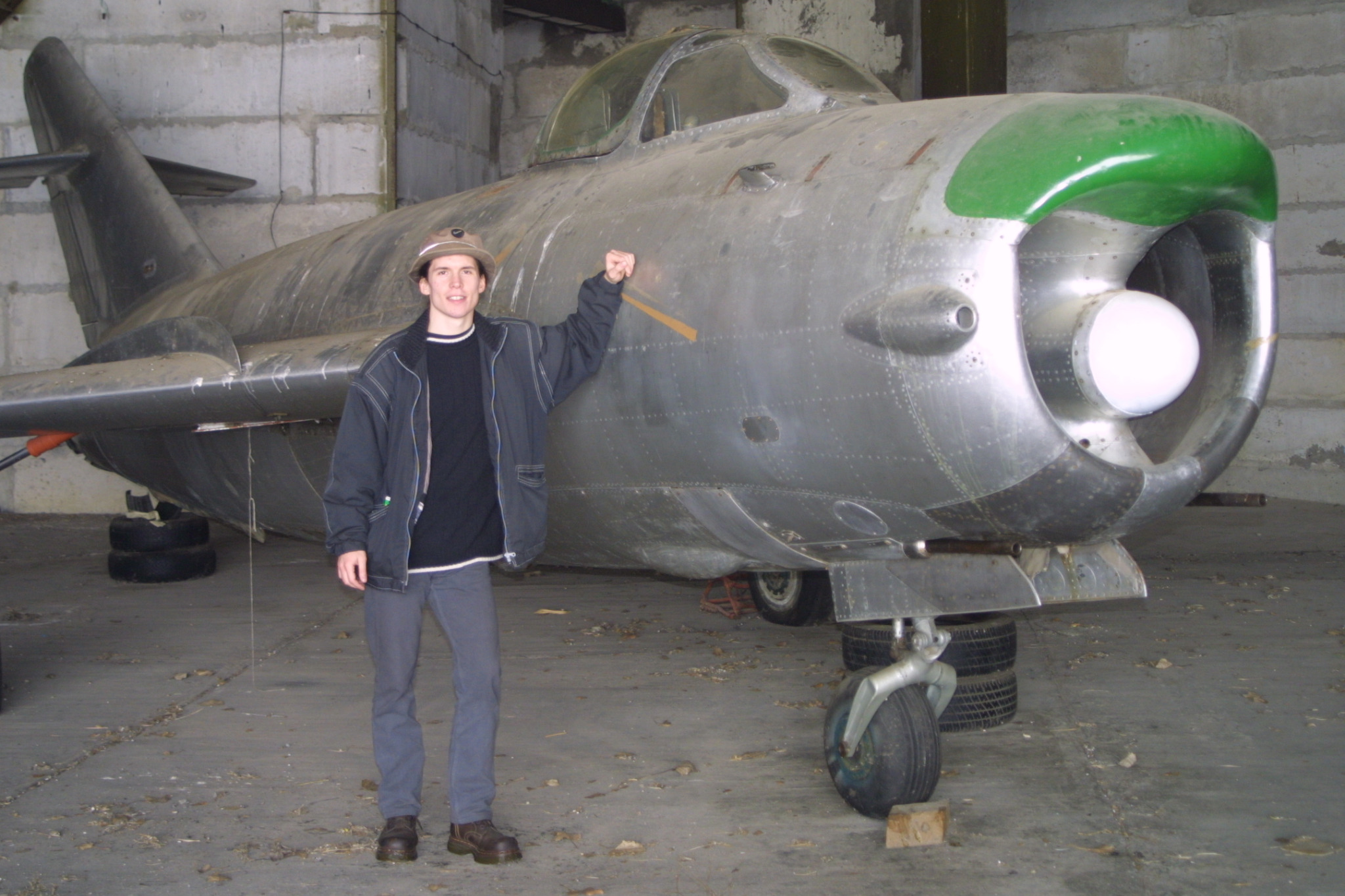 Tamas Martenyi standing beside the MiG-17 in a Debrecen hangar